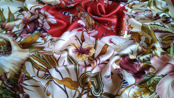 Silk fabric with an amazing colorful floral pattern is laid out in  waves.  Natural multi color smooth satin with a rich color scheme is perfect for the background .